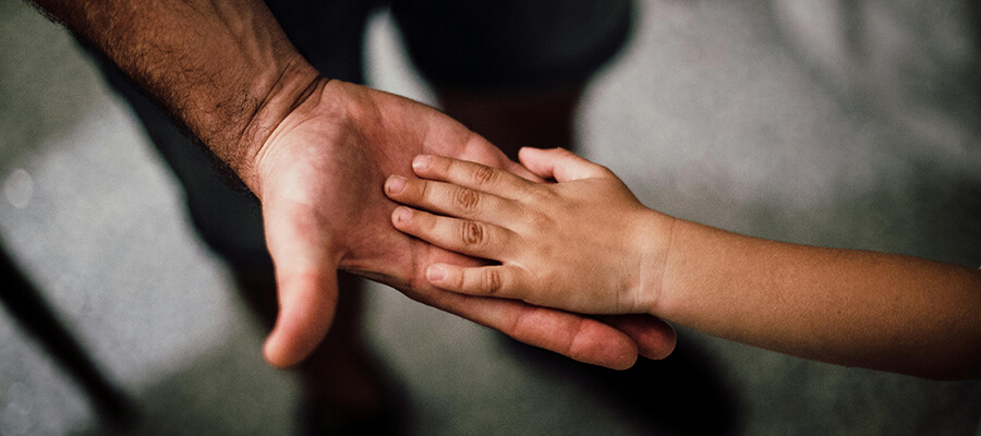 Adult and child hand touching.