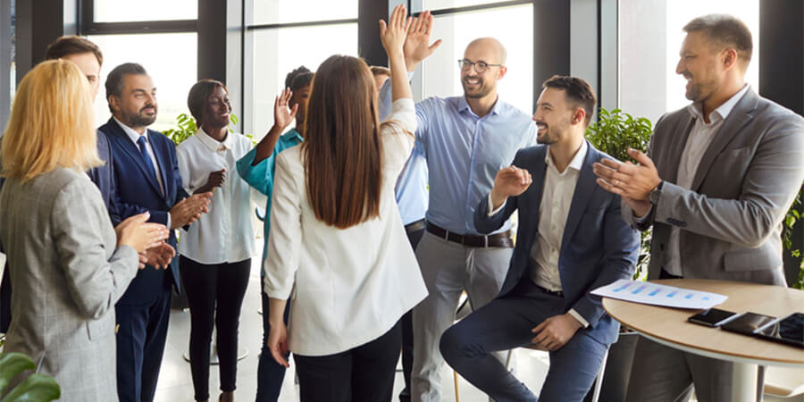 Group of people in an office giving a high-five.