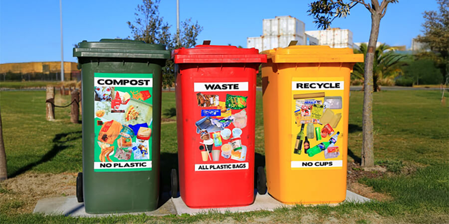 Three wheelie bins: Green Compost, Red Waste and Yellow Recycle.