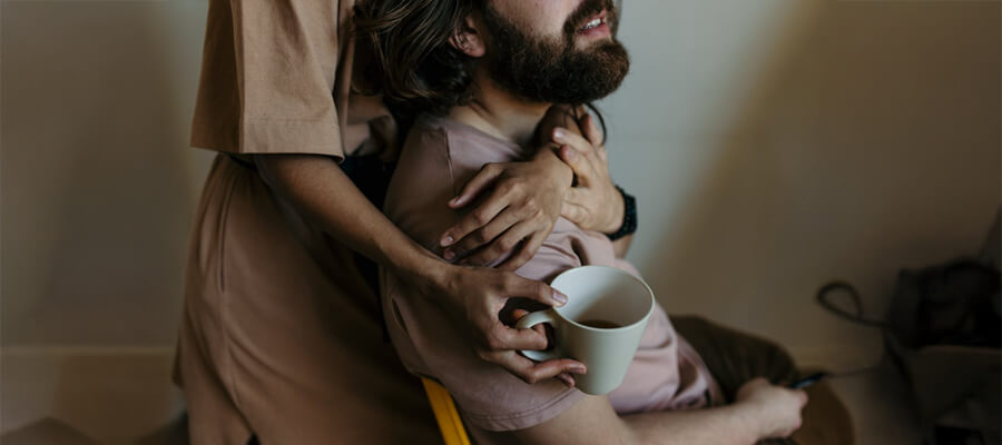 Couple hugging with a cup of coffee.