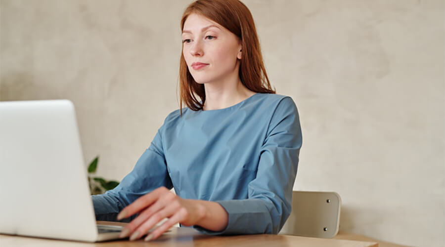 Woman with blue blouse using a laptop