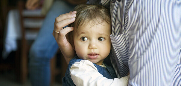 Small child held by parent.