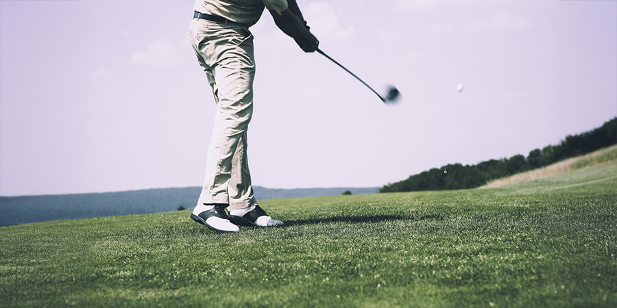 A golfer taking a shot on a golf course.