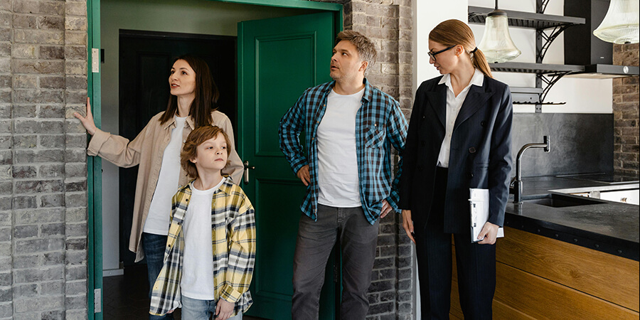 Home buyers looking at a house with an agent.