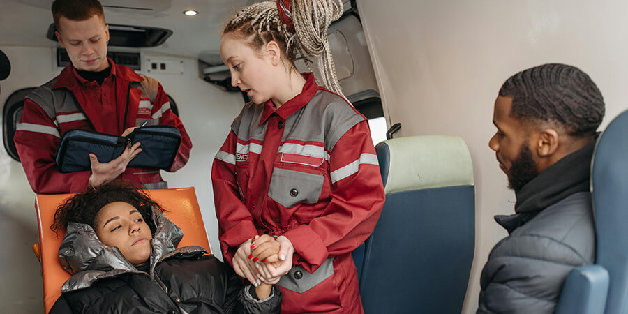 Medical staff helping patient in an ambulance.