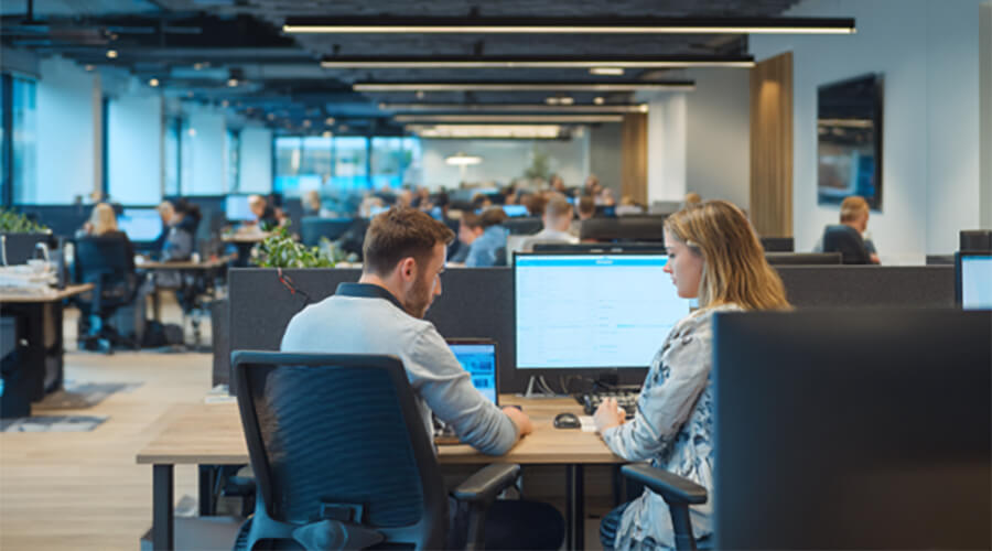 Two people having a conversation in an office space.
