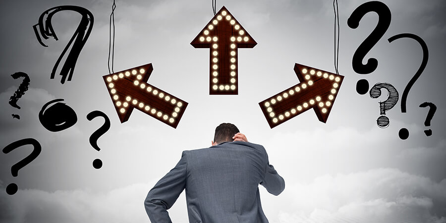 Man in suit with arrows and question marks, to show decision making.