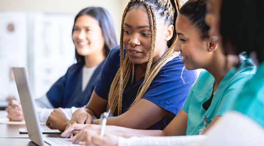 Nurses looking at a laptop while training.