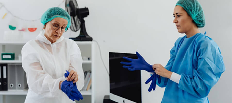 Medical professionals putting on gloves.