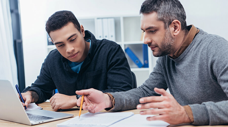 Mentor and mentee sitting together at a desk.