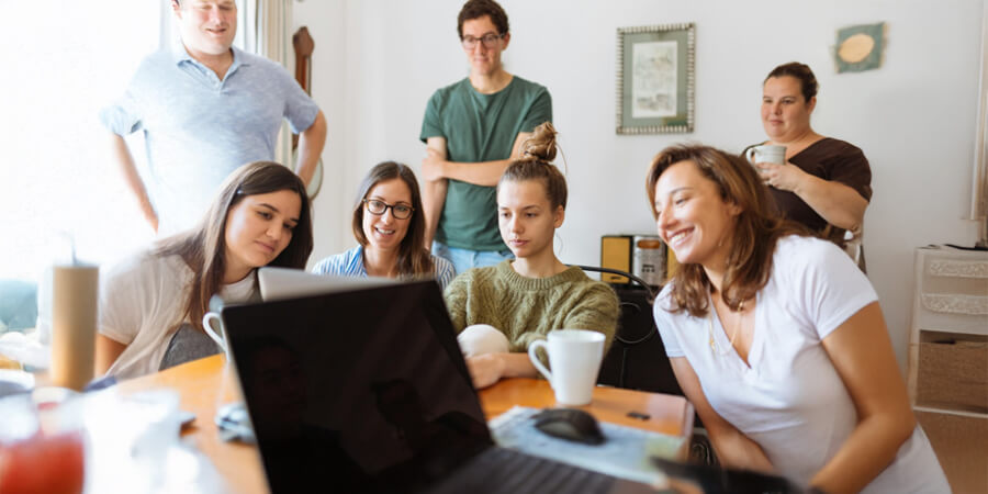 Group of workers looking at a laptop.