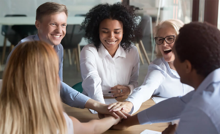 Group of people in an office doing a hand stack.