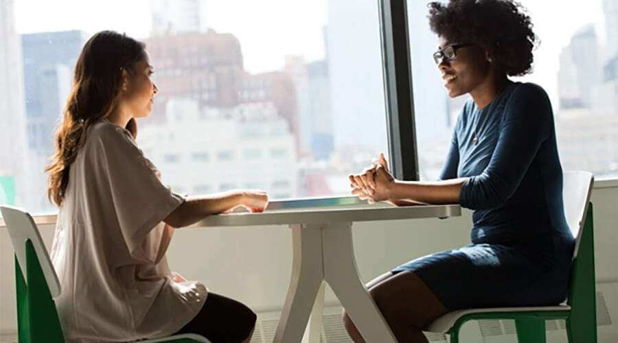 Two people sitting opposite each other at a small round table.