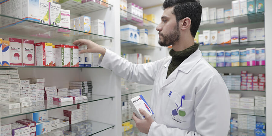 Pharmacist checking drug supplies.