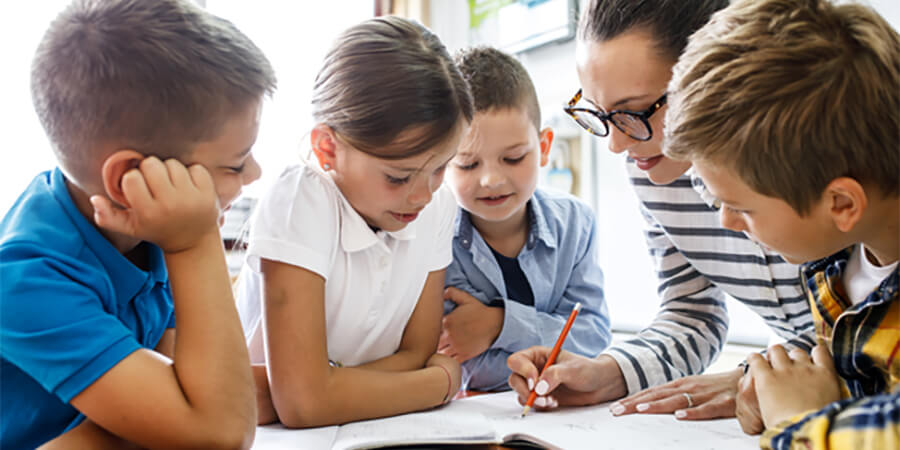 Primary teacher working with a small group of children.