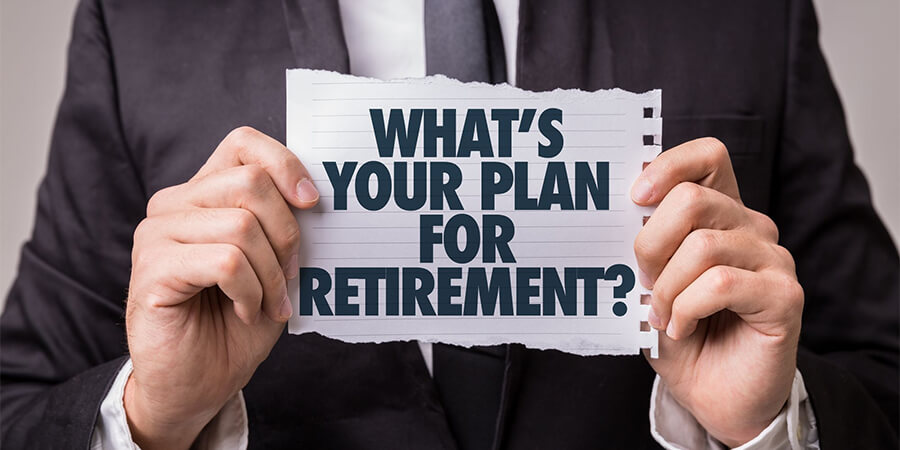 Person holding a piece of paper with 'What's your plan for retirement' printed on it.