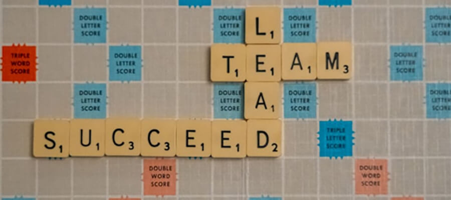 'LEAD, TEAM, SUCCEED' spelt out on a Scrabble board.