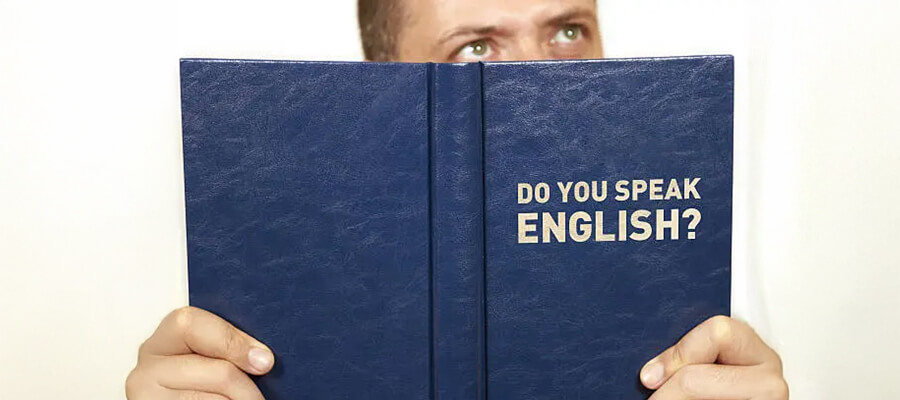 Man reading a book called 'Do you speak English?'