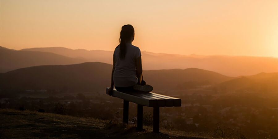 Looking over a sunset from a bench in the mountains.