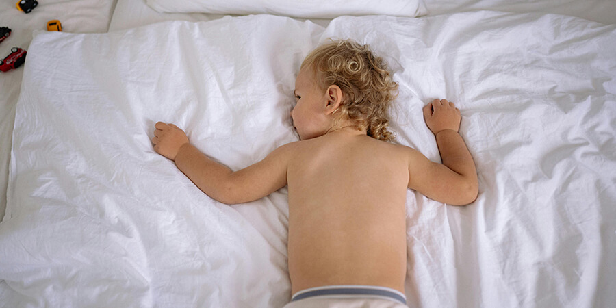 Toddler on a big bed.