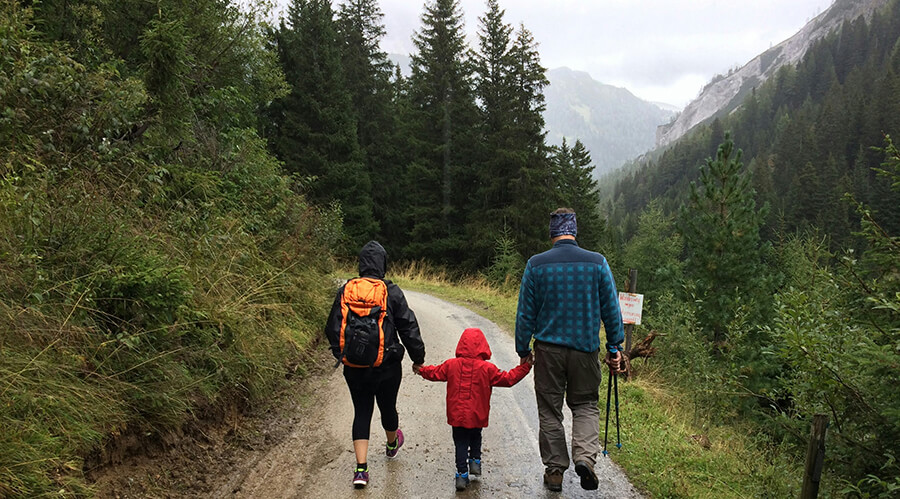 Parents walking on a forest track with their child.
