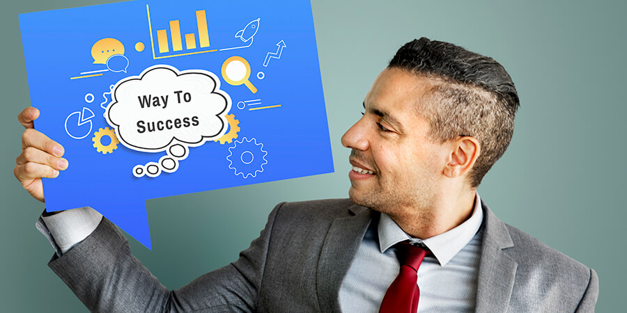 Man holding a card that says 'Way to Success'