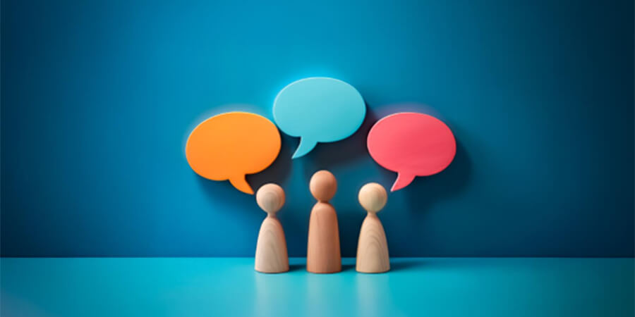 Basic wooden models of people with speech bubbles.