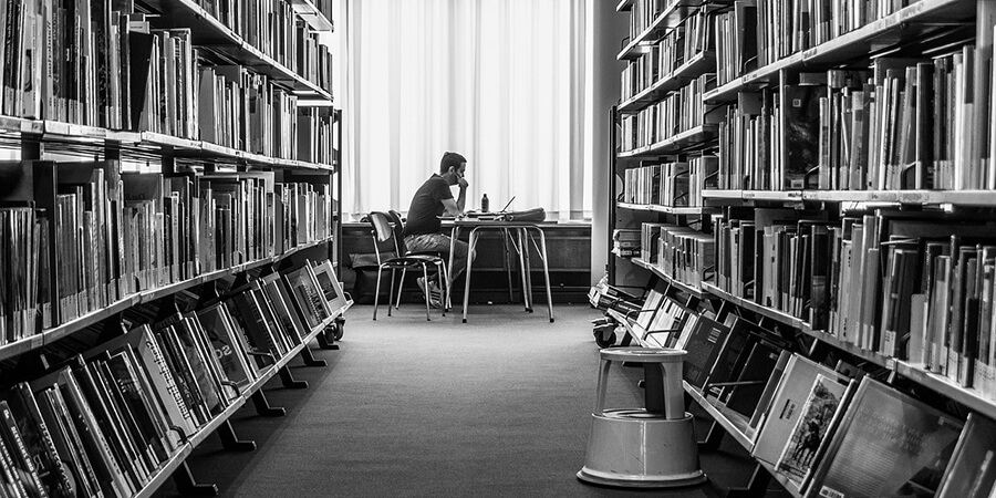 Black and white picture of a man working in a library
